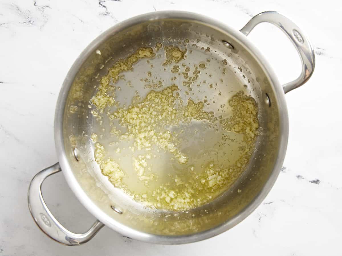 Gehackter Knoblauch in einem Suppentopf mit Olivenöl. 