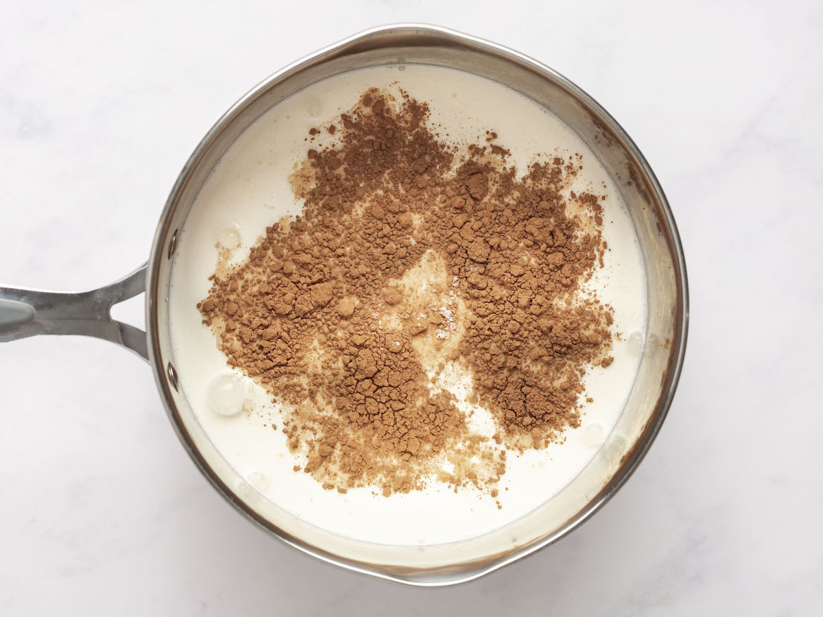 Brauner Zucker, Kakaopulver und Salz zur Milch in Sahne in einem mittelgroßen Topf geben