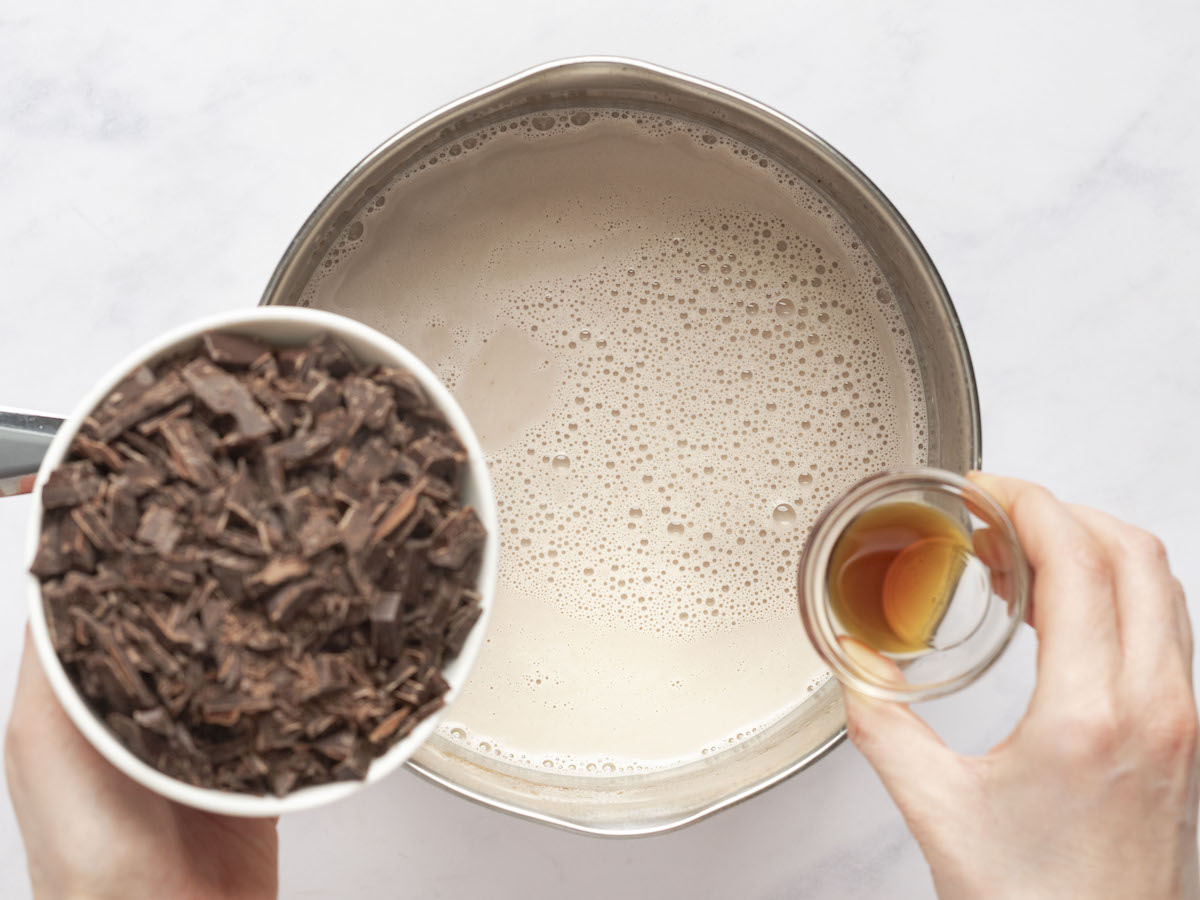Schokolade und Vanille mit der Milchmischung in den Topf geben
