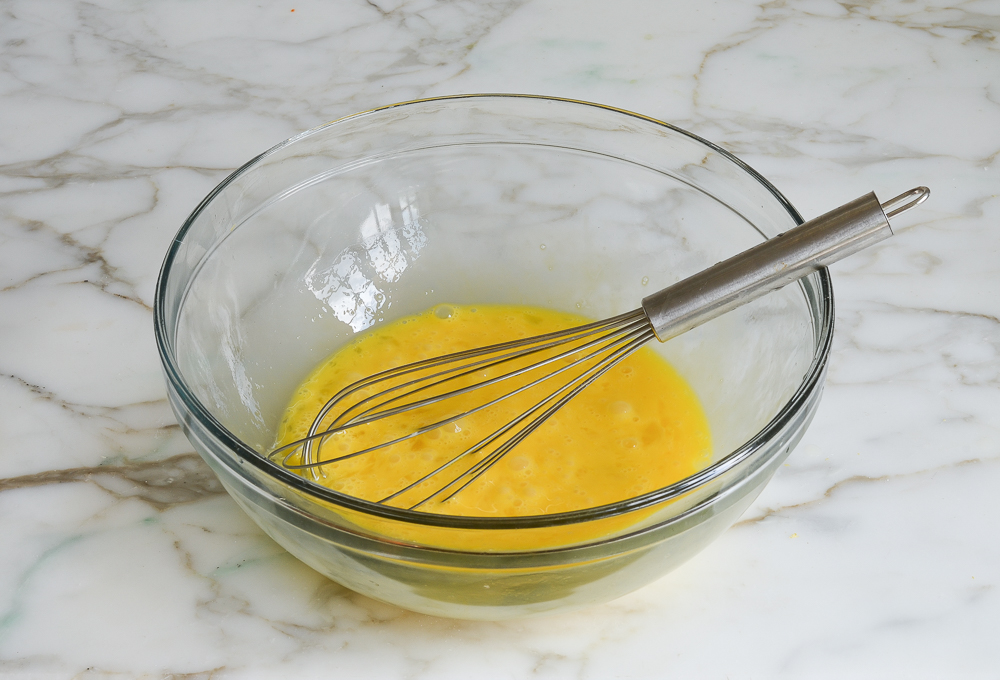 Verquirlte Eier in einer Schüssel für die Zitronenfüllung