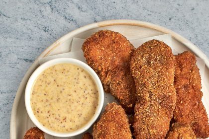 pecan crusted chicken tenders on plate with honey mustard sauce