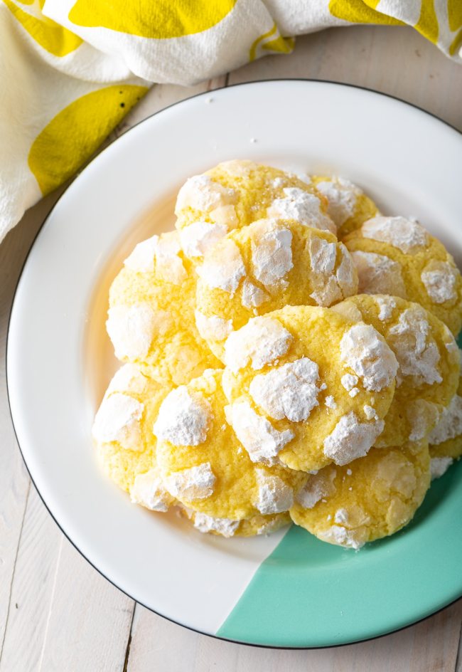 Übereinander gestapelte Zitronen-Crinkle-Kekse auf einem weißen Teller. 
