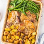 A baking sheet with potatoes and green beans.